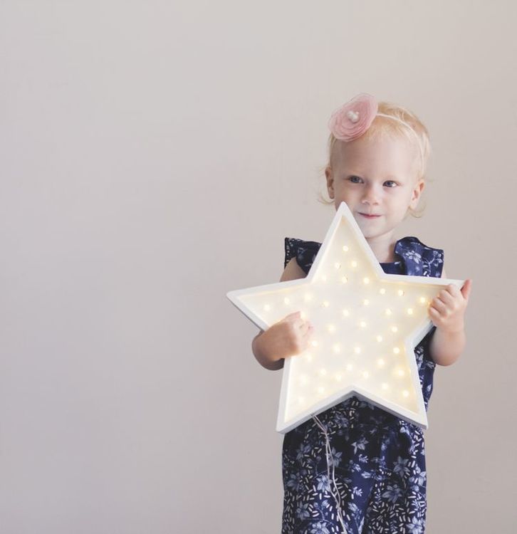 young girl holding star-shaped lamp